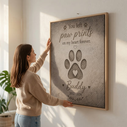 Woman hanging personalized paw print dog memorial canvas on wall